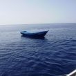 Een Arabische boot drijft leeg midden op zee tussen Pantelleria en Lampedusa
