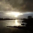 Uit het keukenraam zien we woest kolkende regenwolken boven de rivier