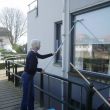 Ans reinigt onze vensters van het bouwstof van de verbouwing van de havenkade