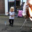 Varkenmarkt. Caelan speelt luchtgitaar. Zie je dat flesje?