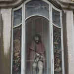 Uit een kast aan de Sint Pieterstoren kijkt een sjofele Jezus bedroefd naar opzij.