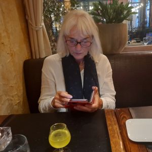 Oostende, 18 september 2025. Anna in Grieks Restaurant 'El Greco' met limoncello en telefo