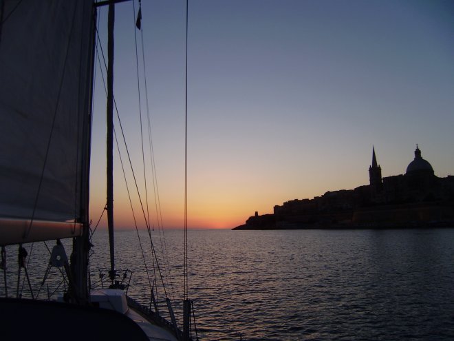 Onder de torens, koepel en pinakels van het oude Valletta varen we Marsamxett Harbour uit in de richtin van de opkomende zon