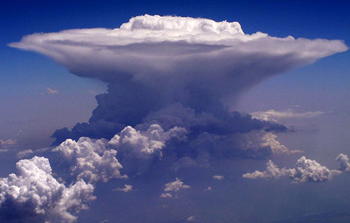 Foto van een cumulonimbus, de typische onweerswolk met zijn aambeeld-vorm, die bundels anti-materie de ruimte in stuurt