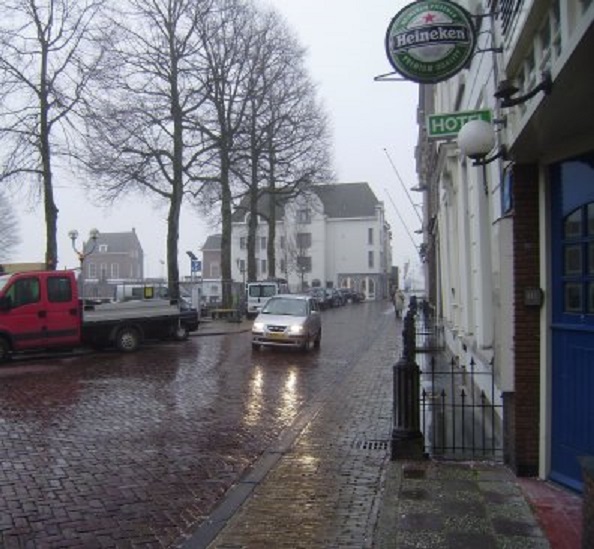 Een kille miezerregen vanmiddag. In het lichtgrijs gekleurde pand op de achtergrond wonen we aan de linkerzijde