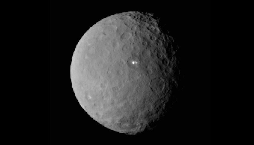 De dwergplaneet Ceres, gefotografeerd door de ruimtesonde Dawn op 49.000 kilometer hoogte. Let op die twee heldere plekken. Ze liggen in hetzelfde bassin (bron: NASA)