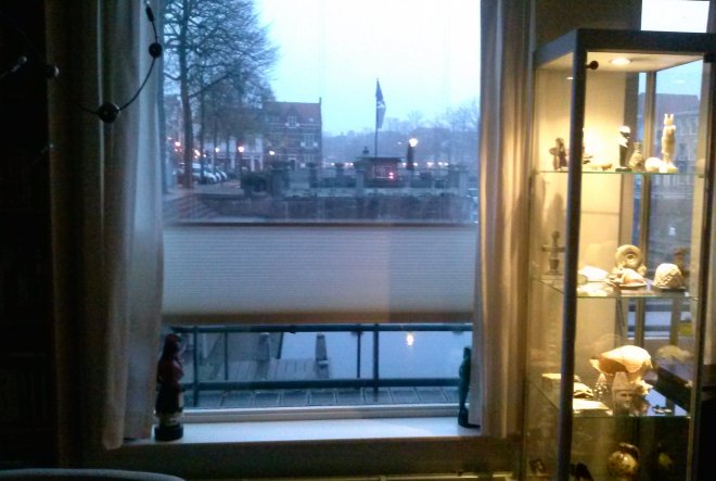 Nieuw boven/onder-rolgordijn. Rechts de vitrinekast met souvenirs van onze zeilreizen.