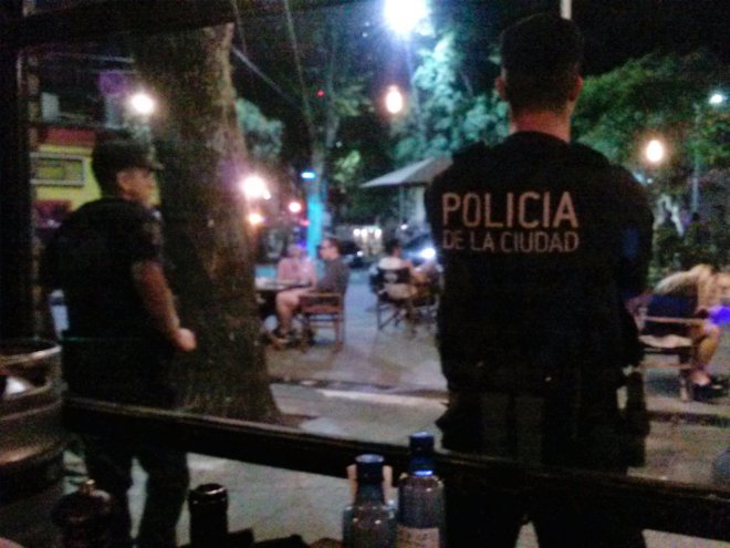 Bewapende politie voor ons restaurant, vrolijke mensen buiten op het terras. Om middernacht gaat alles dicht
