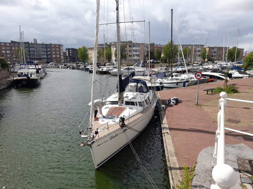 Dulce in het Balkengat te Middelburg. Anna maakt het zonnedek schoon. Onze dinghy ligt al op de kade voor zijn laatste reis.
