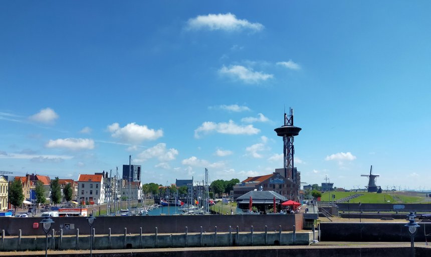 Vlissingen vanaf de boulevard. Vlnr. de Michiel de Ruijterhaven, Brasserie Evertsen, Het Arsenaal met de uitkijktoren en de Oranjemolen aan de kust van de Westerschelde.